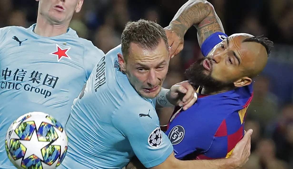 Gelandang Barcelona, Arturo Vidal berebut bola dengan pemain Slavia Praha, Vladmir Coufal pada pertandingan lanjutan Grup F Liga Champions di stadion Camp Nou, Spanyol (5/11/2019). Barcelona bermain imbang 0-0 atas Slavia Praha. (AP Photo/Emilio Morenatti)