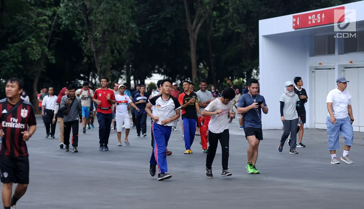 Warga berlari-lari melintasi kawasan lingkar luar Stadion Gelora Bung Karno (GBK), Jakarta, Minggu (21/1). Pascarenovasi, kawasan sekitar Stadion GBK kembali dipadati warga yang berolahraga. (Liputan6.com/Helmi Fithransyah)