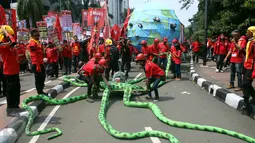 Massa buruh dari KASBI membawa gurita raksasa, bola dunia dan tikus pada peringatan May Day di Bundaran HI, Jakarta, Senin (1/5). Replika gurita itu dianggap simbol penghisap sumber daya alam yang ada di Indonesia. (Liputan6.com/Angga Yuniar)