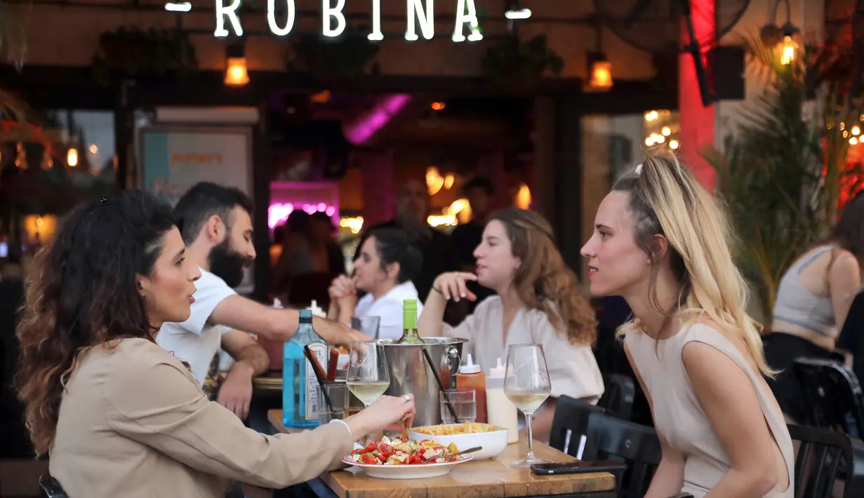 Orang-orang menikmati makanan di kafe di Abima Square di kota Tel Aviv, Israel (20/5/2021). Israel dan dua kelompok bersenjata utama Palestina di Gaza, Hamas dan Jihad Islam, menyetujui gencatan senjata untuk mengakhiri konflik selama 11 hari. (AFP/Gideon Markowicz)