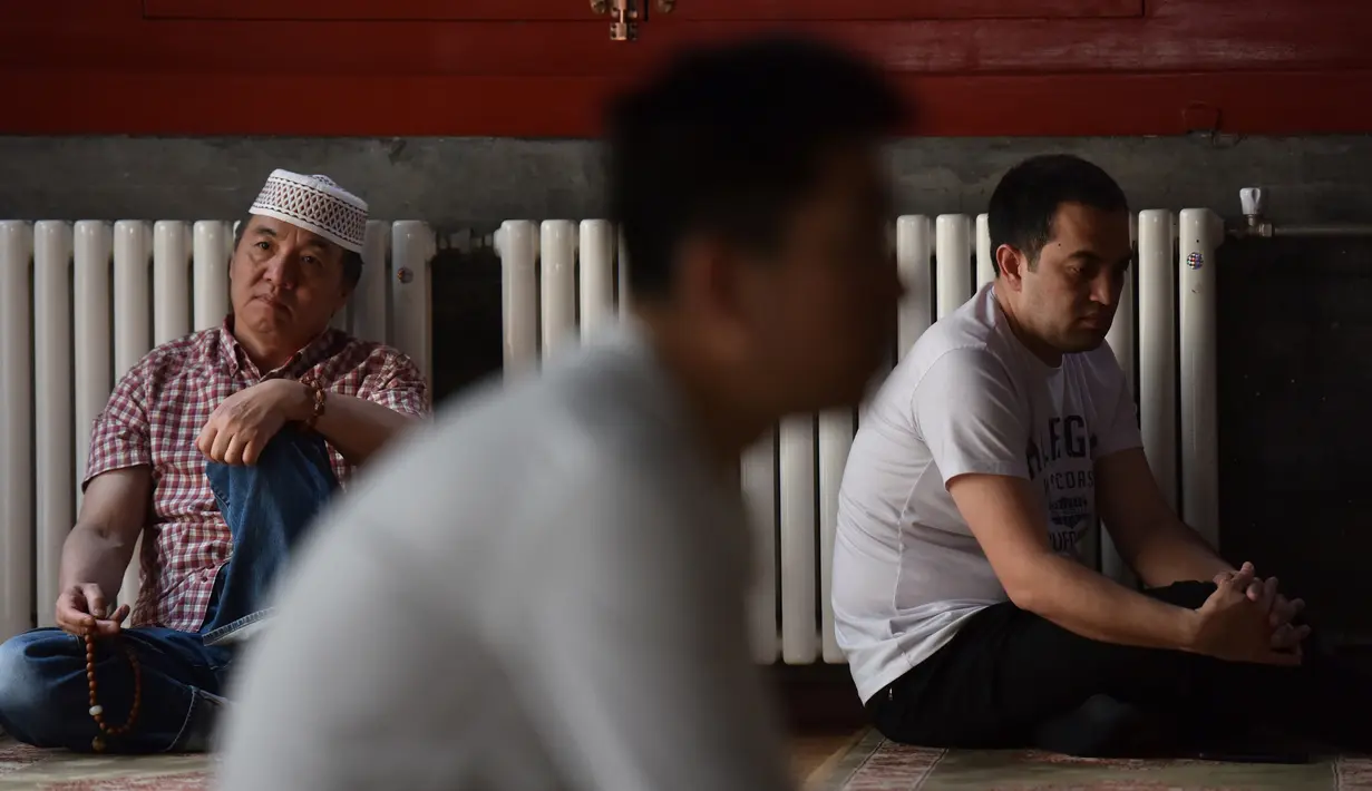 Sejumlah pria muslim mendengarkan ceramah sebelum salat Jumat pertama pada bulan Ramadan 1440 H di sebuah masjid di Beijing (10/5/2019). (AFP Photo/Greg Baker)
