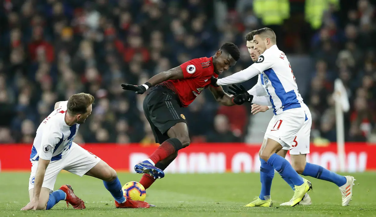 Gelandang Manchester United, Paul Pogba, berusaha melewati pemain Brighton and Hove Albion pada laga Premier League di Stadion Old Trafford, Sabtu (19/1). Manchester United menang 2-1 atas Brighton and Hove Albion. (AP/Martin Rickett)