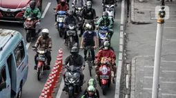 Pengguna sepeda berada di antara pengendara sepeda motor saat melintasi jalur khusus di Jalan Kramat Raya, Jakarta, Kamis (22/9/2022). Penerapan jalur sepeda sepanjang 196,45 kilometer dan tersebar di 26 ruas jalan yang dibangun Pemprov DKI Jakarta itu belum berfungsi secara efektif karena masih diserobot pengendara sepeda motor akibat arus lalu lintas yang semakin padat. (merdeka.com/Iqbal S. Nugroho)