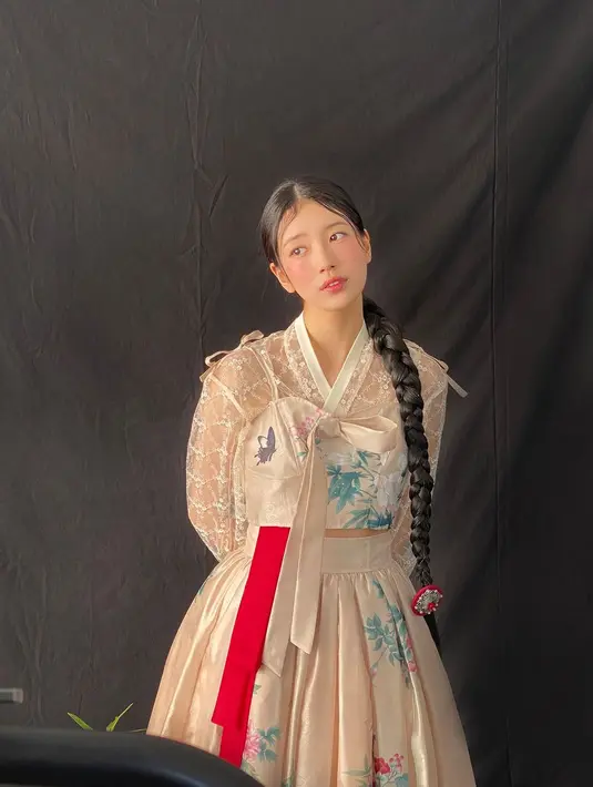 Hanbok selanjutnya yang dikenakan Bae Suzy berwarna cokelat keemasan yang amat cantik. Hanbok ini juga memiliki siluet modern dengan corak floral dan sebuah tali merah. [Foto: Instagram/management_soop]
