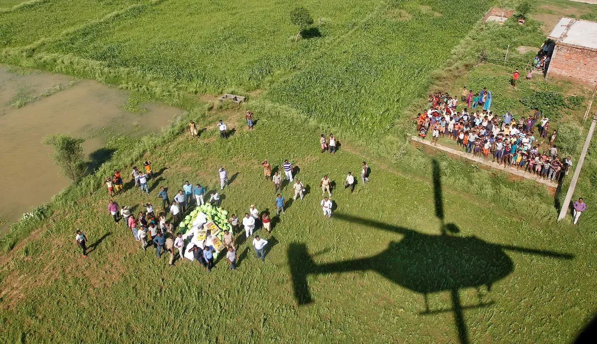 Helikopter Angkatan Udara India meninggalkan lokasi usai mendistribusikan bantuan paket makanan kepada warga korban banjir di pinggiran Allahabad, India, Kamis (25/08). (REUTERS / Jitendra Prakash)