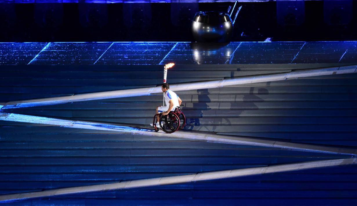 Seorang atler bersiap menyalakan api pada Pembukaan Paralimpik Rio 2016 di Stadion Maracana, Rio de Janeiro (7/8/2016). (AFP/Tasso Marcelo)