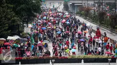 Warga menghadiri Car Free Day di Bundaran HI, Jakarta, Minggu (13/11). Meski gerimis di kawasan tersebut mereka tak surut untuk berolahraga. (Liputan6.com/Faizal Fanani)