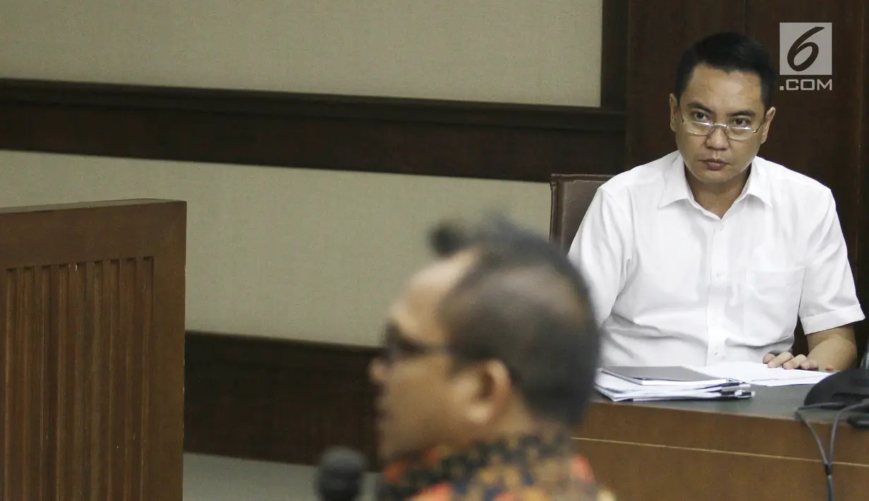 Terdakwa mantan anggota Komisi I DPR, Fayakhun Andriadi (kanan) mendengarkan keterangan saksi Sekretaris DPD Golkar Basri Baco dalam sidang dugaan suap Bakamla di Pengadilan Tipikor, Jakarta, Rabu (12/9). (Liputan6.com/Herman Zakharia)