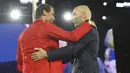 Petenis asal Spanyol, Rafael Nadal, berpelukan setelah menerima obor dari legenda sepak bola Prancis, Zinedine Zidane, dalam acara pembukaan Olimpiade Paris 2024 di Sungai Seine, Prancis. (Stephanie Lecocq/Pool Photo via AP)