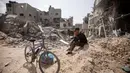 Seorang warga Palestina duduk di antara puing-puing bangunan yang hancur setelah pasukan Israel meninggalkan Khan Younis, Jalur Gaza, Rabu, 6 Maret 2024. (AP Photo/Mohammed Dahman)