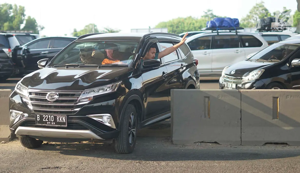 Pengendara mobil menerobos pagar pembatas jalan tol di KM 30 Tol Jakarta - Cikampek, kawasan Cikarang, Jawa Barat, Minggu (9/6). Kemacetan yang terjadi di sepanjang jalur tersebut menyebabkan sebagian kendaraan nekat menerobos pagar pembatas untuk berpindah jalur. (Liputan6.com/Immanuel Antonius)