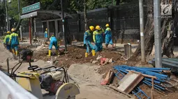 Pekerja menyelesaikan pembangunan pedestrian di Jalan Lapangan Banteng, Jakarta, Minggu (16/7). Pemprov DKI Jakarta menargetkan dapat membangun pedestrian sepanjang 45 kilometer per tahun. (Liputan6.com/Helmi Afandi)