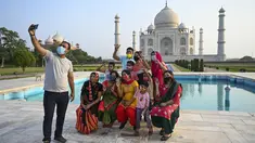 Sekelompok wisatawan berfoto dengan latar belakang Taj Mahal setelah dibuka kembali untuk pengunjung di Agra, Rabu (16/6/2021). Taj Mahal, yang terkenal sebagai ikonik India telah dibuka kembali untuk umum, ketika negara itu mulai melonggarkan pembatasan Covid-19. (Money SHARMA/AFP)