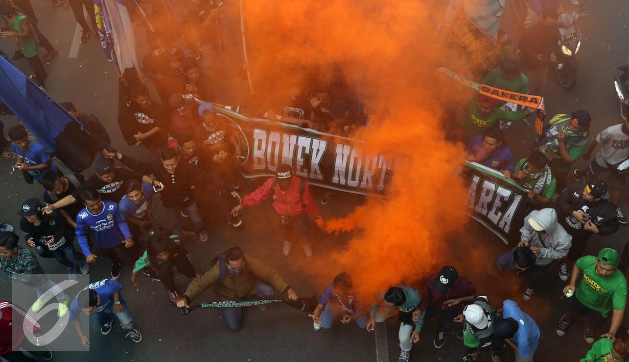 Pendukung Persebaya menyalakan suar di ruas jalan Padjajaran saat merayakan kembalinya klub mereka ke kompetisi PSSI, Bandung, Minggu (8/1). Berdasar putusan Kongres PSSI 2017, Persebaya 1927 kembali ke divisi utama. (Liputan6.com/Helmi Fithriansyah)