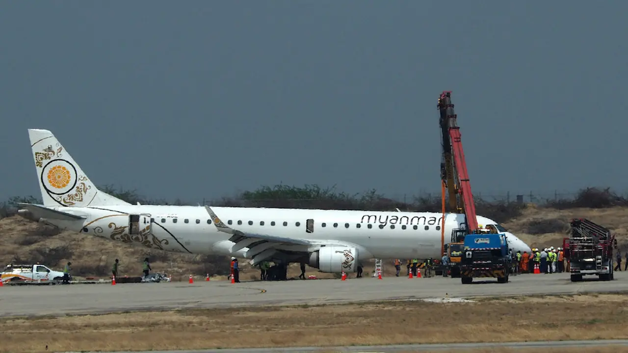 Sebuah pesawat milik maskapai Myanmar National Airlines mendarat tanpa roda depan di Bandara Mandalay, Minggu 12 Mei 2019 (AFP Photo)