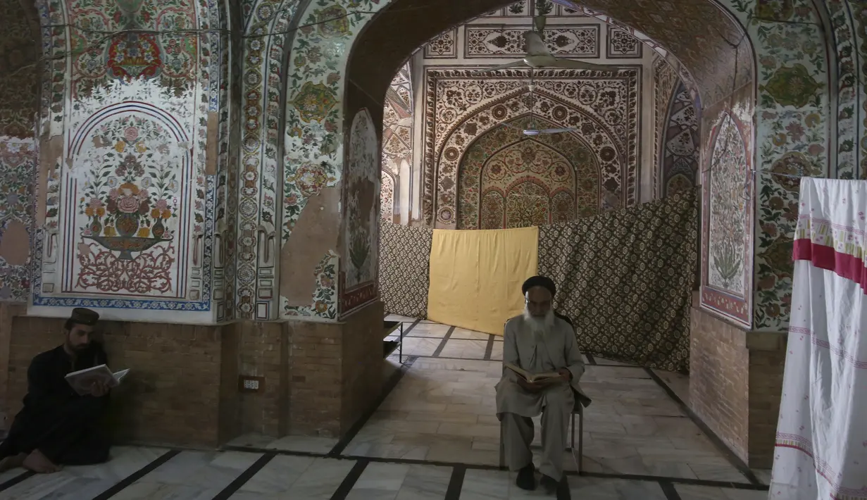 Umat Muslim membaca Alquran saat melakukan "Itikaf" di sebuah masjid di Peshawar, Pakistan, Selasa (11/4/2023). (AP Photo/Muhammad Sajjad)