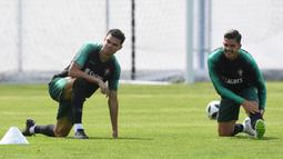 Andre Silva (kanan) dan Pepe melakukan pemanasan saat sesi latihan tim di Kratovo, Moskow, (12/6/2018). Portugal akan mejalani laga perdana grup B melawan Spanyol. (AFP/Francisco Leong)