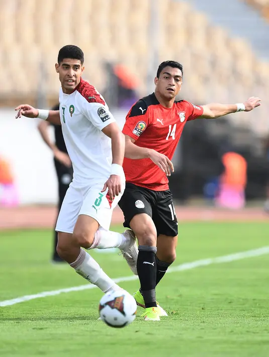 Bek Maroko Adam Masina (kiri) berebut bola dengan penyerang Mesir Mostafa Mohamed selama pertandingan perempat final Piala Afrika (CAN) 2021 di Stade Ahmadou Ahidjo di Yaounde (30/1/2022). Mesir menang atas Maroko 2-1. (AFP/Charly Triballeau)