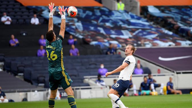 Kiper Arsenal Emiliano Martinez berusaha menangkap bola tembakan striker Tottenham Hotspur, Harry Kane pada pertandingan lanjutan Liga Inggris di Stadion Tottenham Hotspur di London, Inggris, Minggu (12/7/2020). Tottenham menang tipis atas Arsenal 2-1. (Michael Regan/Pool via AP)