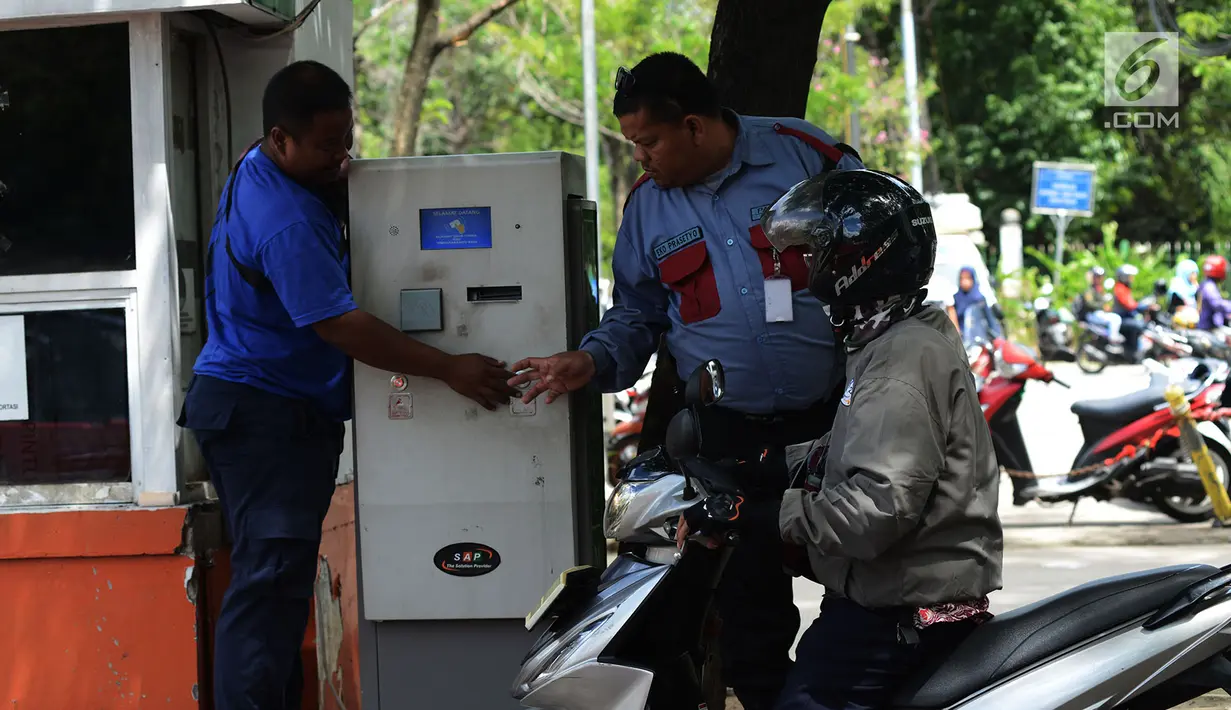 Petugas melayani pengendara motor mengambil karcis parkir di Kawasan Irti Monas, Jakarta, Kamis (3/1). Tarif layanan parkir baru tersebut kemudian akan diterapkan di sejumlah lokasi parkir lainnya. Merdeka.com/Imam Buhori)