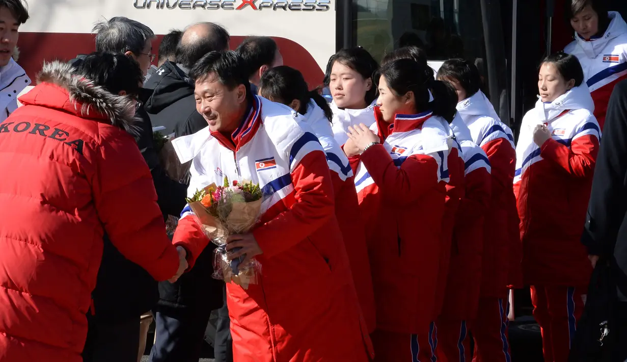 Tim Korea Selatan (kiri) menyambut kedatangan tim hoki es Korea Utara saat tiba di pusat pelatihan nasional Jincheon, Korsel (25/1). (AFP Photo/Pool/ Kyung-Seok)