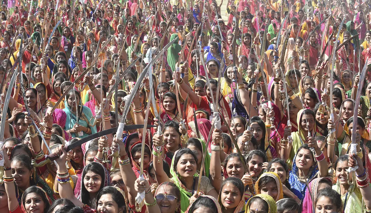 Wanita dari komunitas Shatriya menari dengan pedang dalam upaya untuk menetapkan rekor dunia dalam tarian pedang  di Rajkot,  Ahmedabad, India (28/1/2020). Acara ini bagian dari upacara penobatan tiga hari raja Rajkot ke-17, Thakorsaheb Mandhatasinh Jadeja. (AFP/Sam Panthaky)