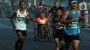 Peserta disabilitas memacu kursi roda balapnya di antara para peserta lomba lari bertajuk Lo Gue Run (LGR) 2020 di Kompleks Monas, Jakarta Pusat, Minggu (26/1/2020). Kodam Jayakarta menggelar lomba lari 'Loe Gue Run' yang merupakan puncak perayaan HUT ke-70 Kodam Jaya. (Liputan6.com/Johan Tallo)
