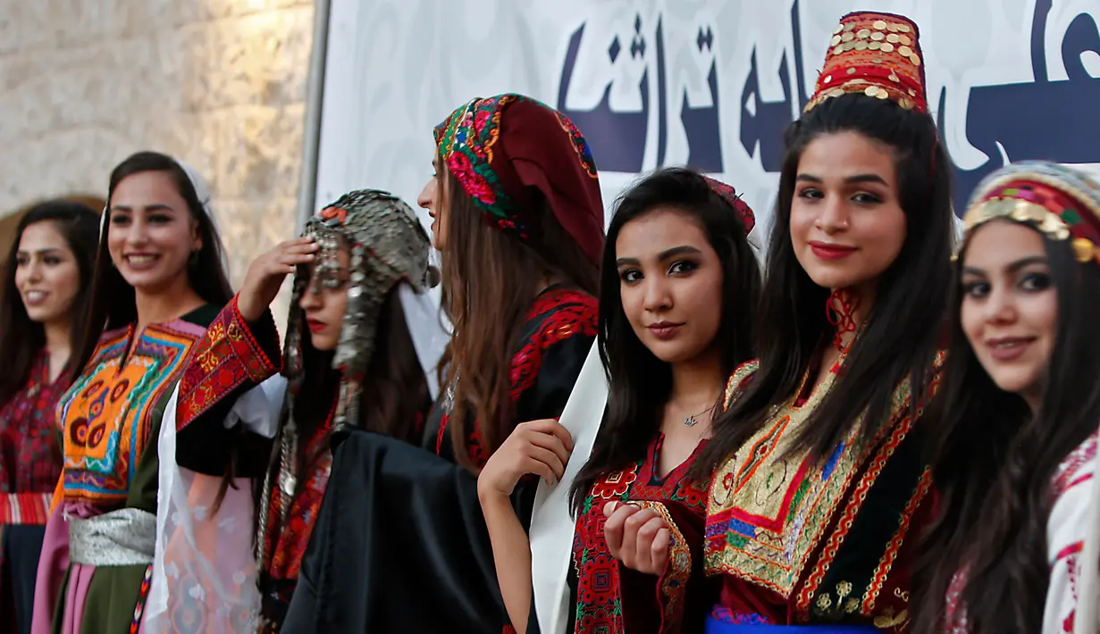 Sejumlah model menunggu giliran saatm mengikuti peragaan busana tradisional Palestina di Kota Tua Nablus, Tepi Barat, Palestina, Selasa (22/8). Peragaan busana ini sebagai salah satu upaya untuk melestarikan budaya Palestina. (AFP Photo/Jaafar Ashtiyeh)