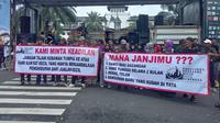 Sejumlah pedagang asal Subang yang terdampak pembongkaran jongko membentangkan spanduk tuntutan di depan Gedung Sate, Kota Bandung Selasa, 10 Juni 2025. (Liputan6.com/Dikdik Ripaldi).