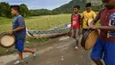 Sejumlah anak laki-laki mengambil bagian dalam tari Rapa'i Geleng di sepanjang sawah di desa ekowisata Nusa, Lhoknga, Provinsi Aceh, 26 September 2021. Biasanya, yang memainkan tarian ini ada 12 orang laki-laki yang sudah terlatih. (CHAIDEER MAHYUDDIN/AFP)