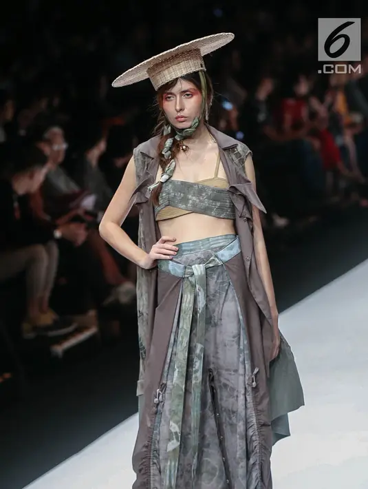 Model memperagakan busana rancangan HUMBANG SHIBORI x PURANA saat Jakarta Fashion Week (JFW) 2019 di Senayan City, Jakarta, Kamis (25/10). HUMBANG SHIBORI x PURANA mengangkat tenun ikat tradisional Humbang Shibori. (Liputan6.com/Faizal Fanani)