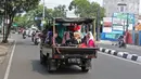 Sejumlah warga menaiki kendaraan bak terbuka saat bepergian libur lebaran menuju Kebun Binatang Ragunan di kawasan Jakarta, Minggu (9/6/2019). Warga memilih berpergian dengan mobil bak terbuka dan truk walau sangat membahayakan keselamatan mereka. (Liputan6.com/Herman Zakharia)