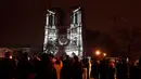 Kerumunan orang berdiri di luar Katedral Notre-Dame yang diterangi lampu saat upacara yang menandai pembukaan kembali katedral yang menjadi ikon kota Paris ini, di pusat kota Paris, pada tanggal 7 Desember 2024. (Dimitar DILKOFF/AFP)