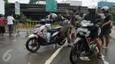 Sejumlah pengendara motor mengecek kendaraan mereka setelah menerobos banjir di Jalan Raya Kalimalang, Caman, Bekasi, Senin (20/2). Banjir setinggi 80 cm itu menyebabkan jalur dari arah Jakarta menuju Kota Bekasi tersendat. (Liputan6.com/Gempur M Surya)