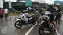Sejumlah pengendara motor mengecek kendaraan mereka setelah menerobos banjir di Jalan Raya Kalimalang, Caman, Bekasi, Senin (20/2). Banjir setinggi 80 cm itu menyebabkan jalur dari arah Jakarta menuju Kota Bekasi tersendat. (Liputan6.com/Gempur M Surya)