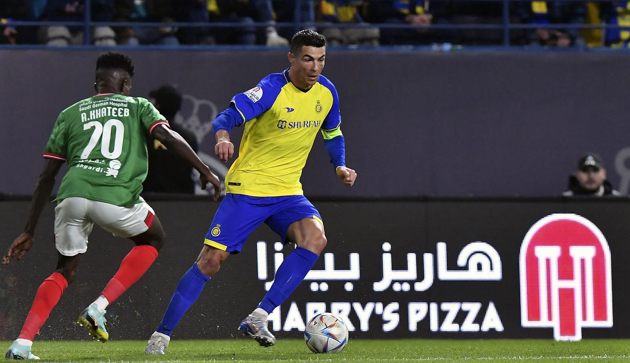 Pemain Al Nassr, Cristiano Ronaldo (kanan) berusaha melewati pemain Al Ettifaq, Abdullah Al-Khateeb saat laga lanjutan Liga Pro Arab Saudi 2022/2023 yang berlangsung di Mrsool Park, Riyadh, Arab Saudi, Minggu (22/01/2023). Al Nassr berhasil menang dengan skor 1-0 dan kini menempati puncak klasemen sementara Liga Pro Arab Saudi 2022/2023. (AP Photo)