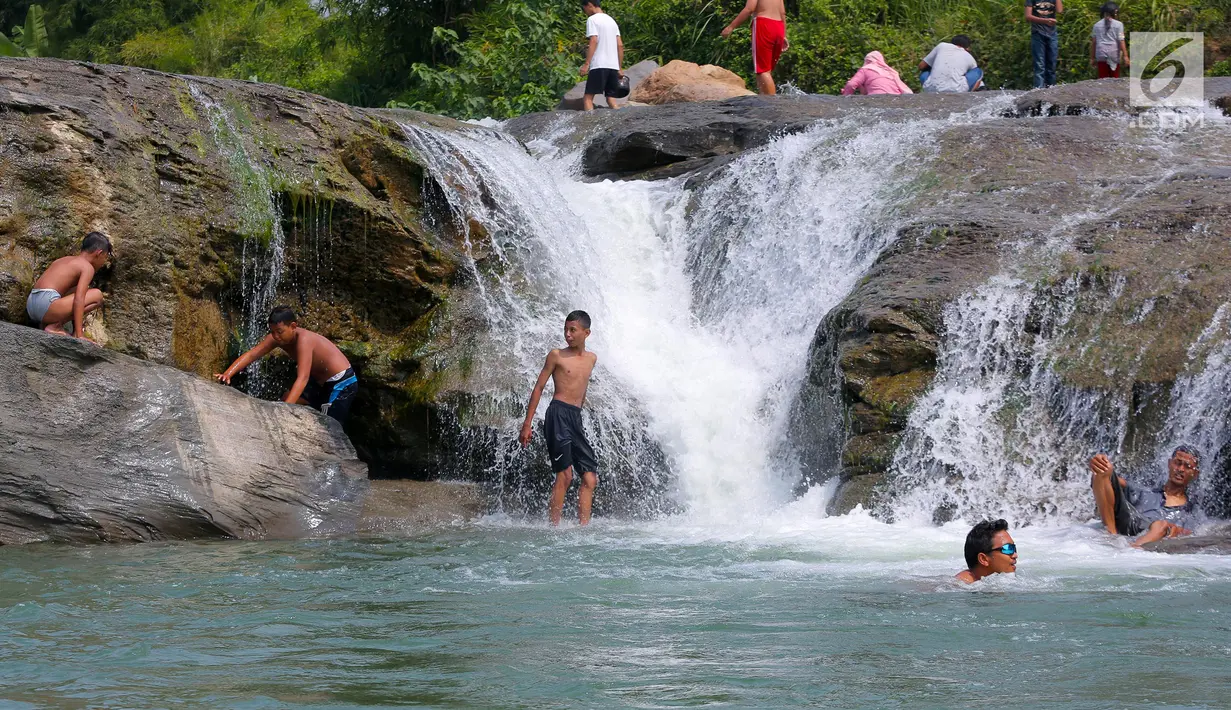 Anak-anak berenang di aliran sungai Gunung Sari, Desa Tajur, Citeureup, Bogor, Jawa Barat (24/6/2019). Wisata gratisan ini berlokasi tepat dibelakang perumahan puri harmoni, panorama hamparan sawah diantara kebun buah menambah semarak wisata ramah lingkungan ini. (Kapanlagi.com/Budy Santoso)
