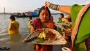 Seorang wanita Hindu diolesi bubuk vermilion di dahinya saat mengikuti festival keagamaan Chhat Puja di Kolkata, India (6/11). Dalam ritual menyembah Dewa Matahari ini mereka meminta kesejahteraan, dan kemakmuran. (Reuters/Rupak De Chowdhuri)