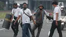 Polisi berpakaian kaus putih mengamankan seseorang yang dicurigai terlibat kericuhan di kawasan Tugu Tani, Jakarta, Selasa (13/10/2020). Sejumlah pemuda diamankan polisi karena dicurigai terlibat kericuhan di kawasan Tugu Tani. (Liputan6.com/Helmi Fithriansyah)