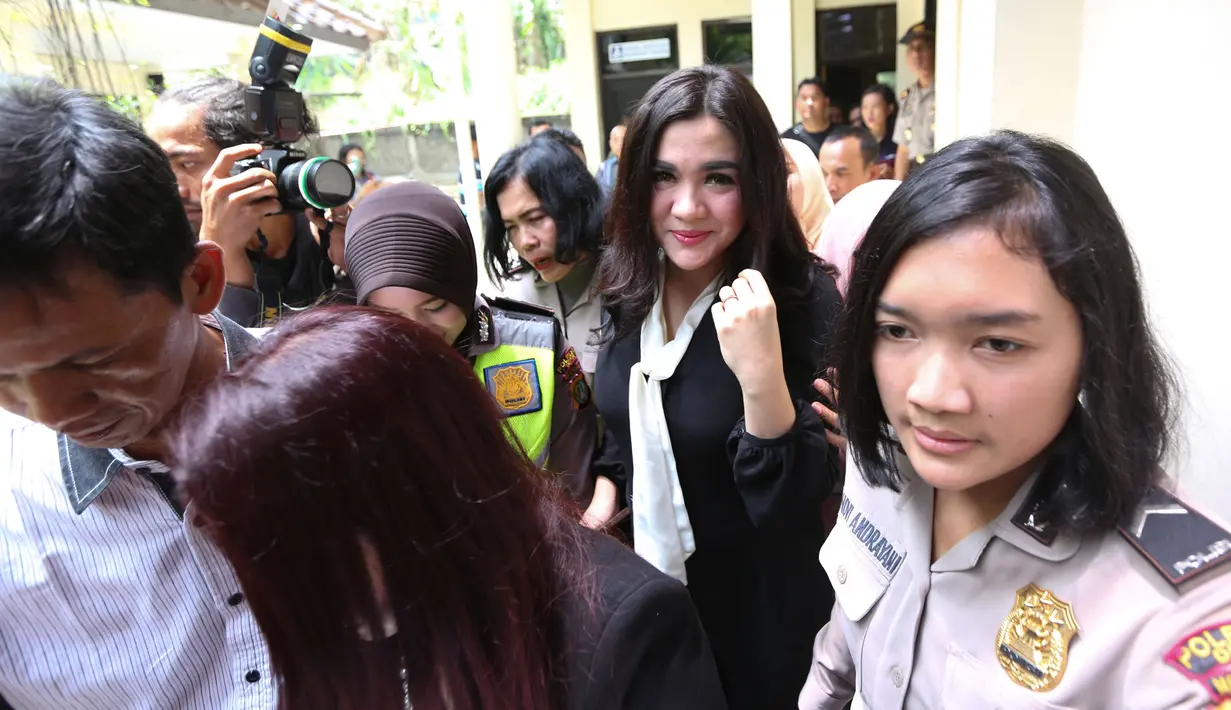 Penyanyi Vicky Shu dikawal sejumlah polwan menuju ruang sidang kasus penipuan First Travel di Pengadilan Negeri Depok, Rabu (14/3). Vicky Shu merupakan satu dari 10 saksi yang dihadirkan di persidangan kasus First Travel hari ini. (Kapanlagi/Budy Santoso)