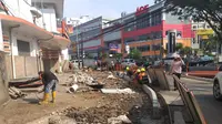Pekerja tengah melakukan revitalisasi trotoar di kawasan Cikini. (Liputan6.com/Luqman Rimadi)