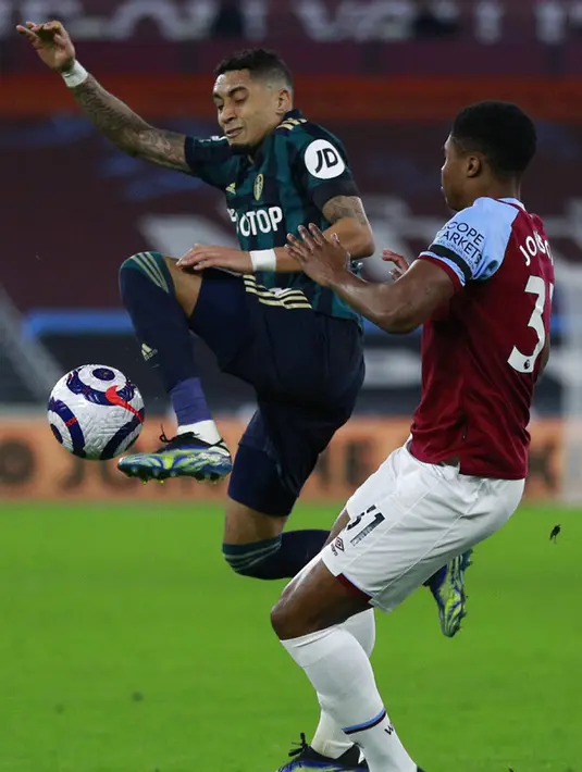 PemainLeeds United Raphinha (kiri) memperebutkan bola dengan pemain West Ham United Ben Johnson pada pertandingan Liga Inggris di Stadion London, London, Inggris, Senin (8/3/2021). West Ham United menang 2-0. (Ian Walton, Pool)