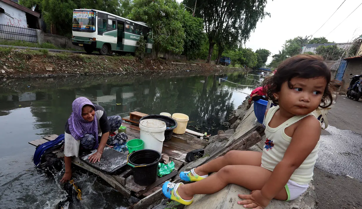 Seorang wanita memanfaatkan aliran Kali Maja untuk mencuci pakaian, Jakarta, Selasa (7/11). Warga dikawasan tersebut terpaksa memanfaatkan air kali untuk mencuci dikarenakan air di rumah mereka keruh dan asin. (Liputan6.com/JohanTallo)