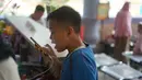 Seorang anak berbicara menggunakan ponsel setelah terpisah dari keluarganya di Taman Margasatwa Ragunan, Jakarta, Kamis (6/6/2019). Membeludaknya pengunjung, membuat banyak orang yang memadati pusat informasi untuk mencari anggota keluarga serta barang berharga. (Liputan6.com/Immanuel Antonius)