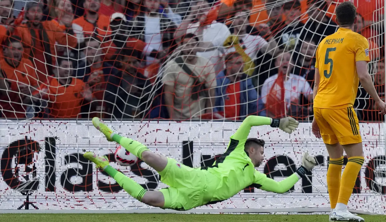 Pemain Wales Chris Mepham menyaksikan kiper Wayne Hennessey gagal menyelamatkan gawangnya dari tendangan pemain Belanda Noa Lang pada pertandingan sepak bola UEFA Nations League di Stadion De Kuip, Rotterdam, Belanda, 14 Juni , 2022. Belanda menang dengan skor 3-2. (AP Photo/Peter Dejong)
