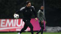 Kiper Juventus, Gianluigi Buffon memegang bola saat mengikuti sesi latihan di Juventus Training Centre di Vinovo (10/4). Juventus akan bertanding melawan Real Madrid pada leg kedua perempat final Liga Champions di Bernabeu. (AFP Photo/Marco Bertorello)