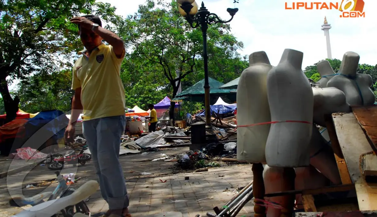 Seorang pedagang Pasar IRTI merapikan dan mengikat patung-patung manekin untuk segera dipindahkan, Selasa (22/4/14). (Liputan6.com/Miftahul Hayat)