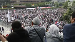 Warga melihat kerumunan peserta aksi massa Gerakan Nasional Kedaulatan Rakyat yang melakukan unjuk rasa di perempatan dekat Gedung Bawaslu, Jakarta, Rabu (22/5/2019). Dalam aksinya, mereka meminta Bawaslu memeriksa kembali hasil Pemilu 2019. (Liputan6.com/Helmi Fithriansyah)