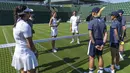 Kate Middleton, petenis juara delapan kali turnamen Wimbledon Roger Federer dan sejumlah penangkap bola berbincang tentang keterampilan yang dipelajari selama pelatihan sebagai penangkap bola.  (Thomas LOVELOCK / AELTC / AFP)