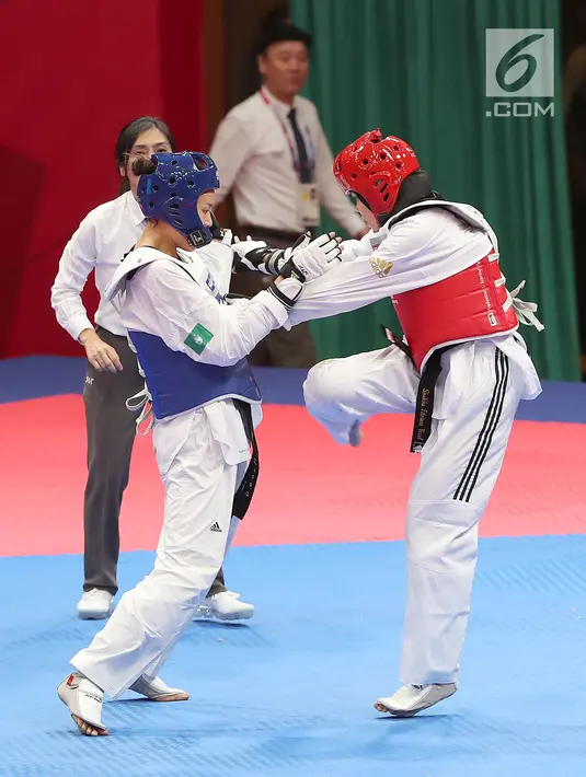Atlet taekwondo putri Indonesia, Fitriyana Yusuf berhadapan dengan Liu Qing dari Makau pada babak 16 besar di Jakarta Convention Center (JCC), Senin (20/8). Fitriyana kalah tipis 21 - 25 pada kelas Wanita 67 kg. (Liputan6.com/Fery Pradolo)